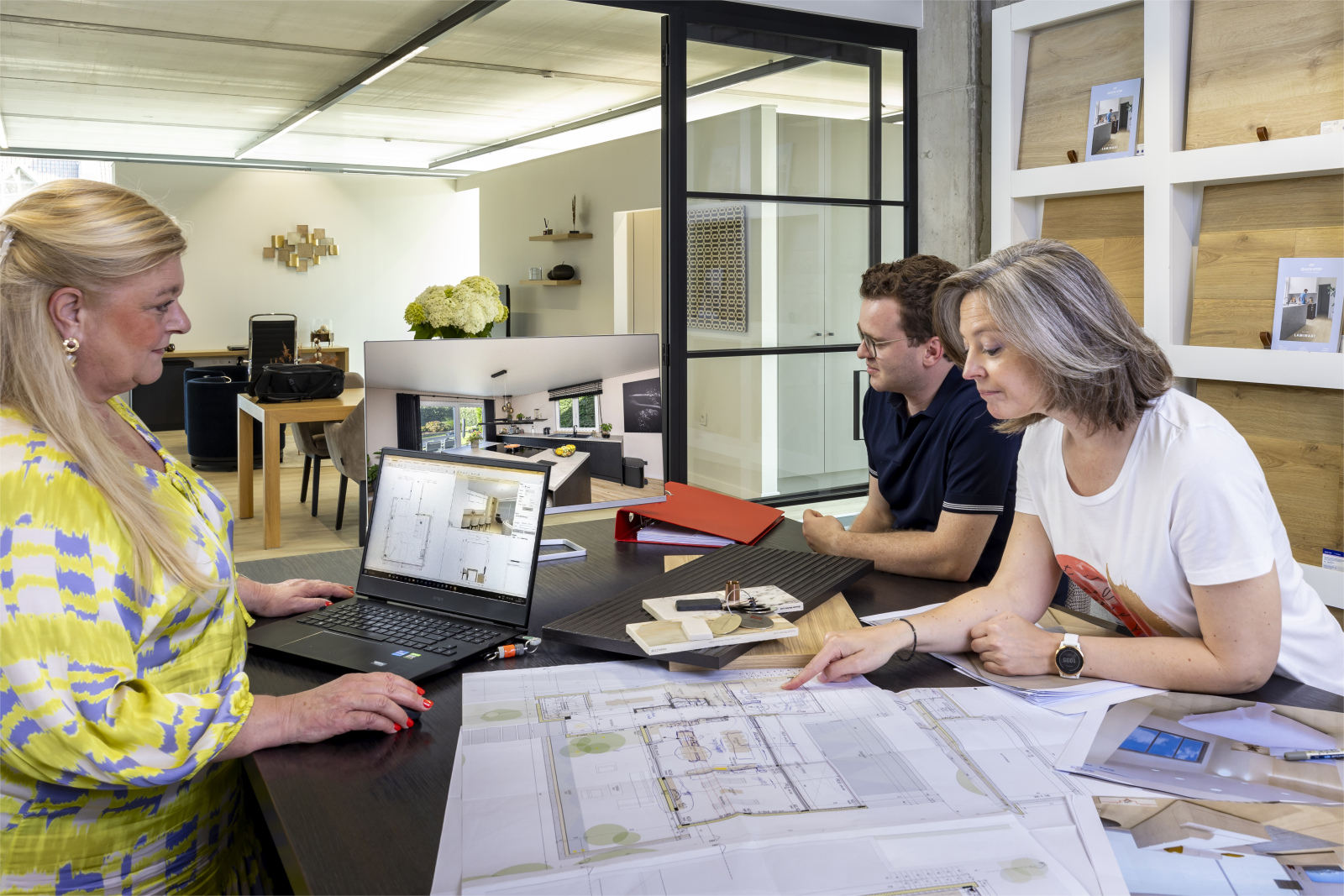 Interieuradviseur bespreekt keukenplannen met klanten in de toonzaal van Janssen Interieur